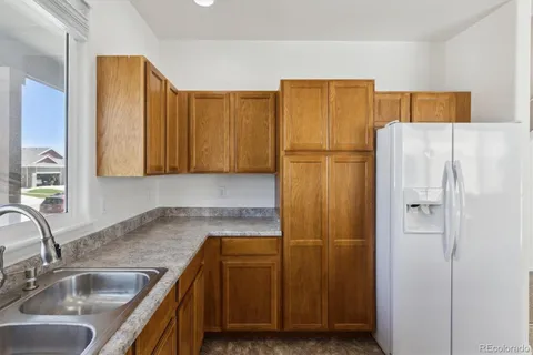 a kitchen with a refrigerator sink and cabinets