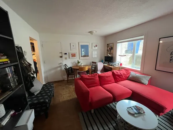 a living room with furniture a flat screen tv and a window