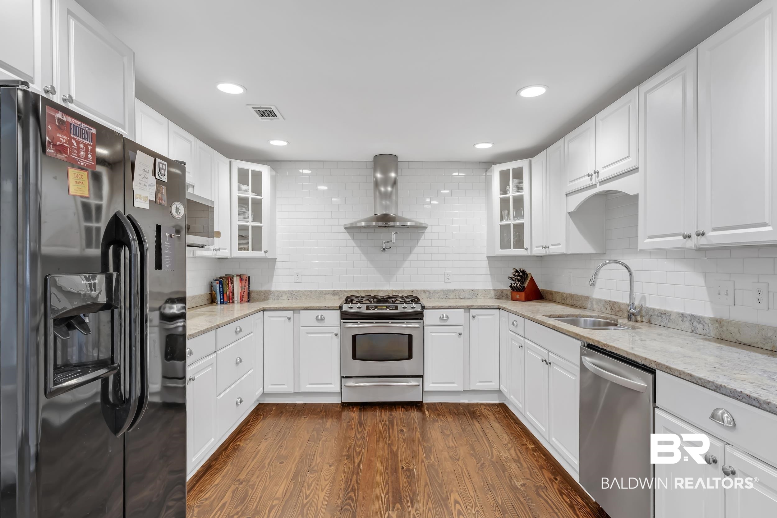 18 York Place Mobile, AL 36608 - Photo 8 of 27 Kitchen with appliances with stainless steel finishes, dark wood-style flooring, tasteful backsplash, light stone counters, and recessed lighting
