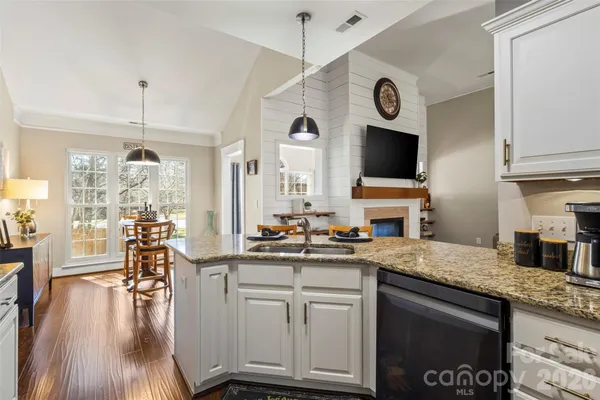 a kitchen with a sink cabinets and wooden floor