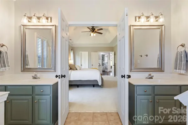 a en suite bathroom with a double vanity sink a mirror and a