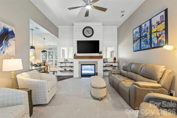 a living room with furniture a fireplace and a flat screen tv