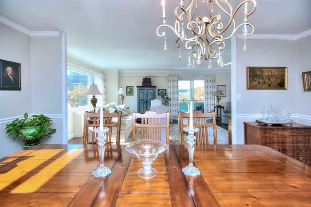 a view of a dining room with furniture a kitchen and chandelier