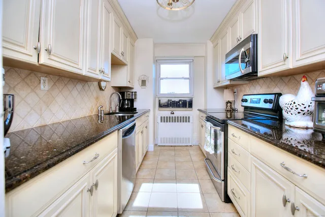 a kitchen with granite countertop a sink a stove and cabinets