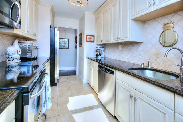 a kitchen with stainless steel appliances granite countertop a sink stove and cabinets