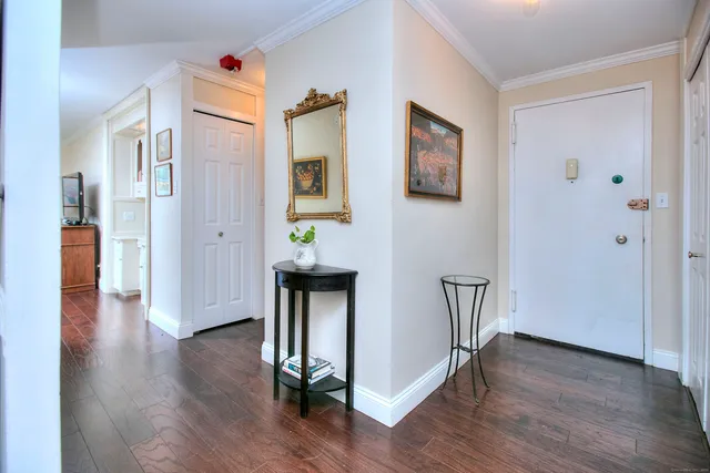 a view of a hallway with wooden floor and cabinets
