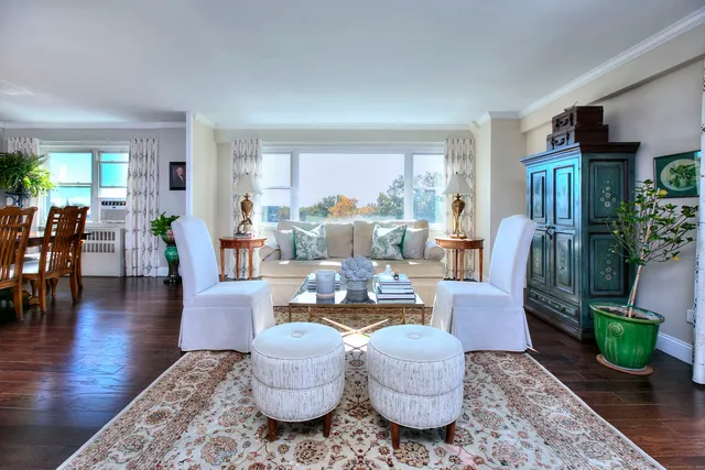 a living room with fireplace furniture and a large window