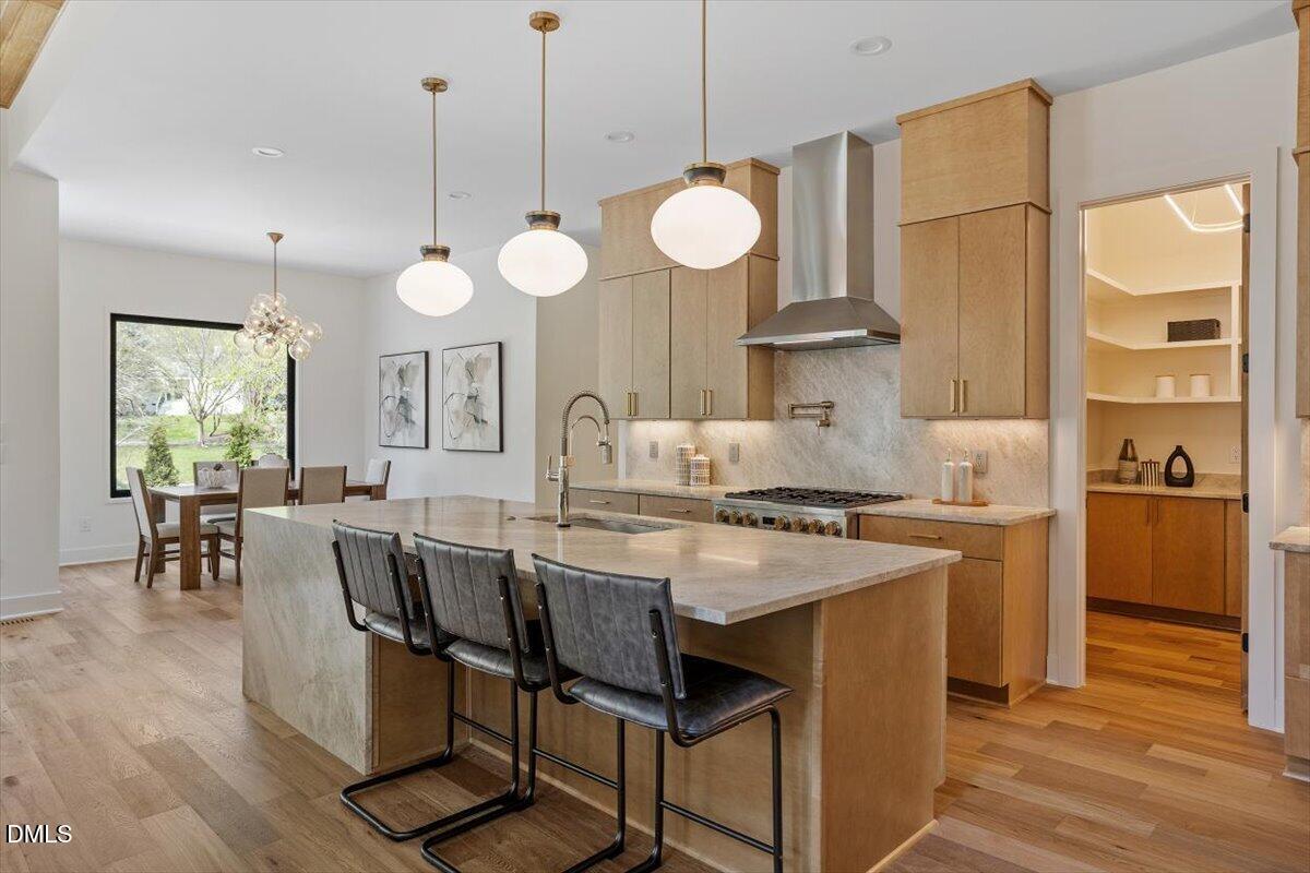 1213 Brookside Drive Raleigh, NC 27604 - Photo 18 of 50 a kitchen with stainless steel appliances a stove a refrigerator a sink a dining table and chairs with wooden floor