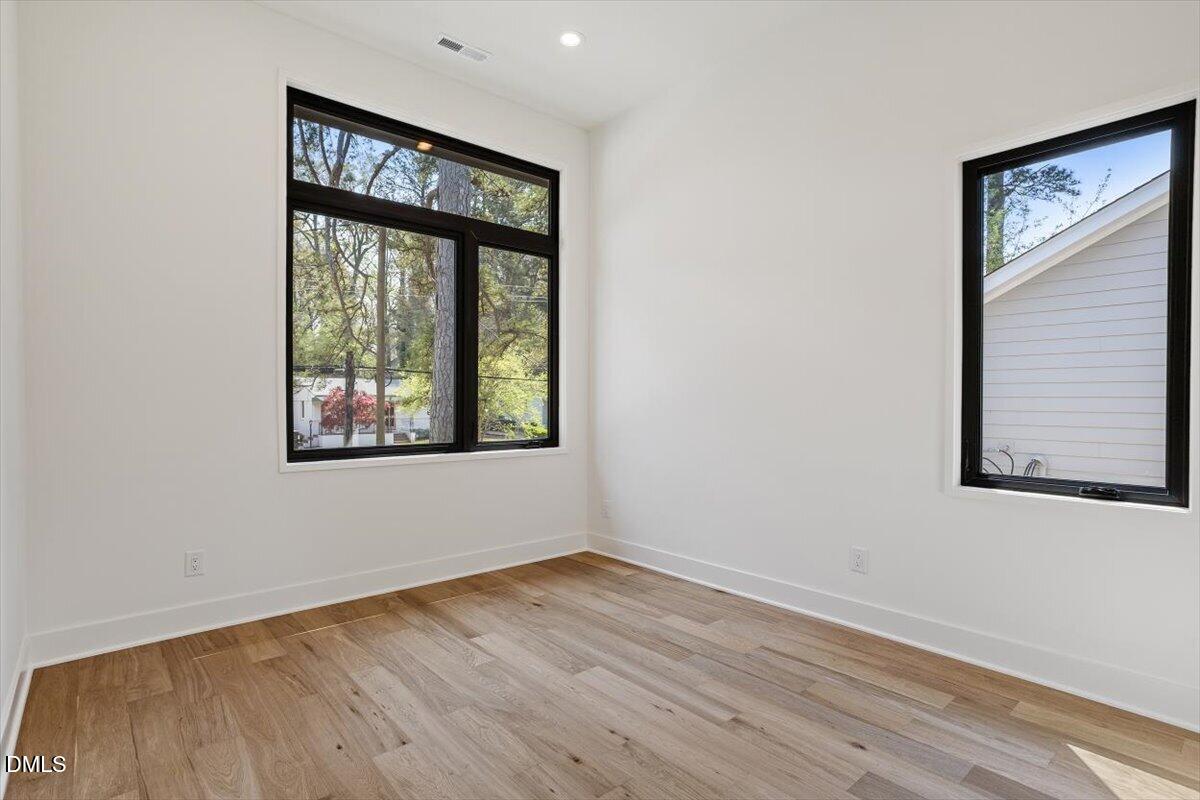 1213 Brookside Drive Raleigh, NC 27604 - Photo 38 of 50 an empty room with wooden floor and windows