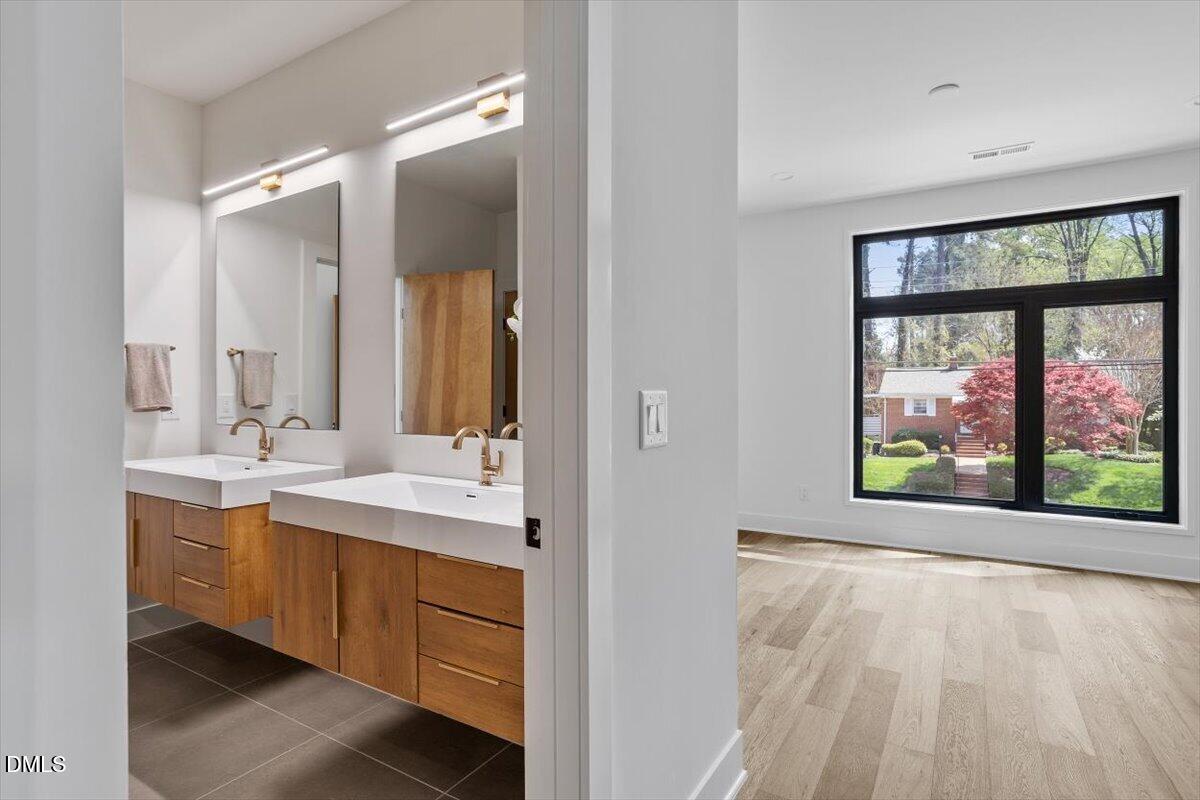 1213 Brookside Drive Raleigh, NC 27604 - Photo 39 of 50 a bathroom with a double vanity sink and large mirror