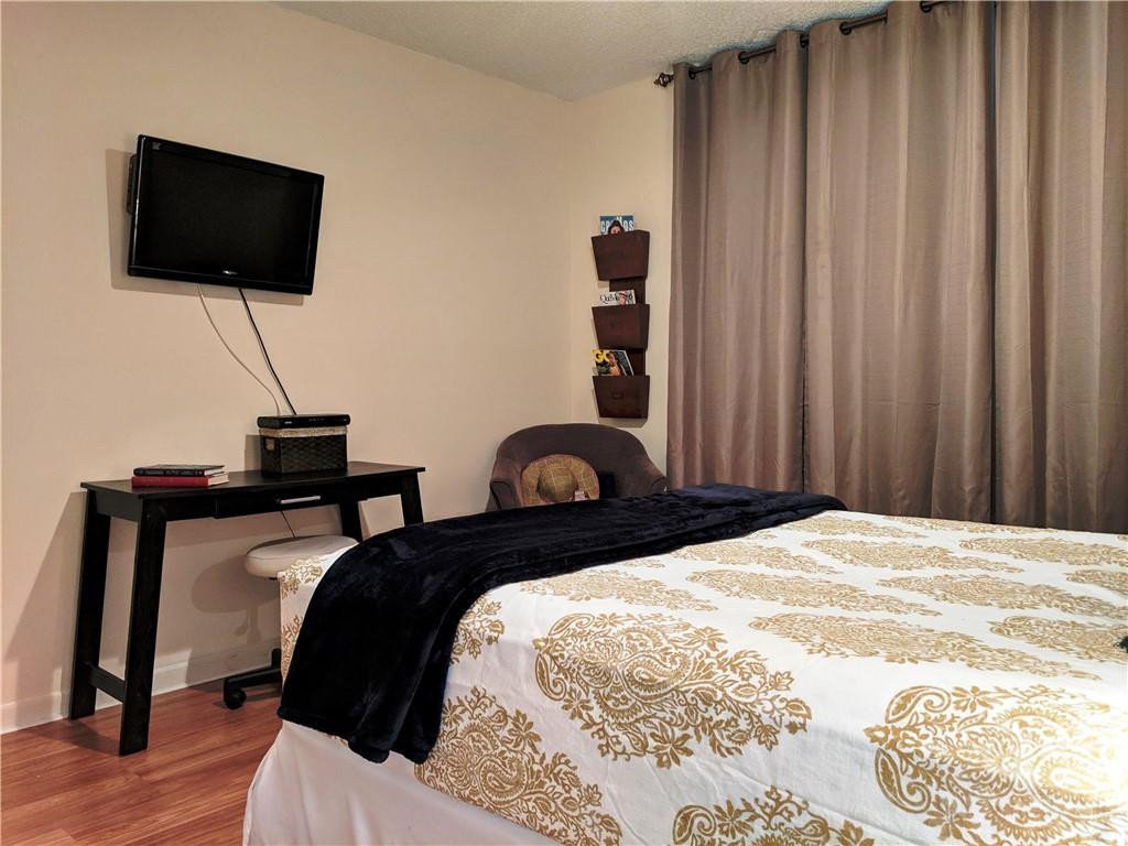 7650 West McNab Road, Unit 310 Tamarac, FL 33321 - Photo 18 of 30 a bedroom with a bed and a flat screen tv
