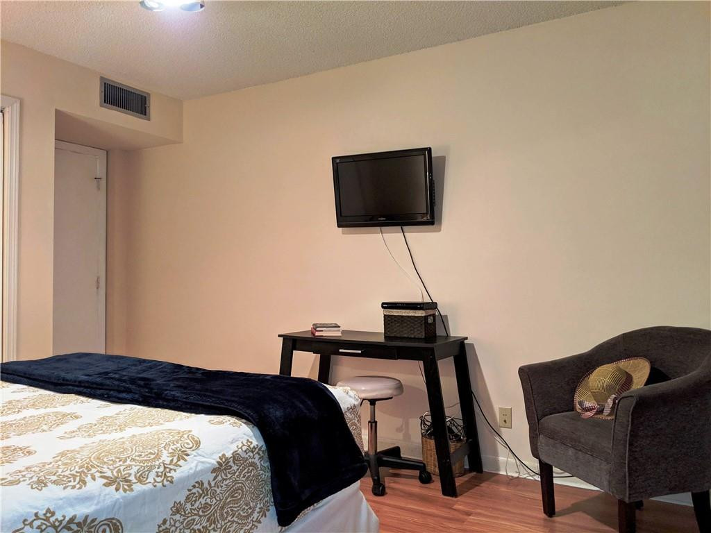 7650 West McNab Road, Unit 310 Tamarac, FL 33321 - Photo 20 of 30 a bedroom with a bed and a flat screen tv
