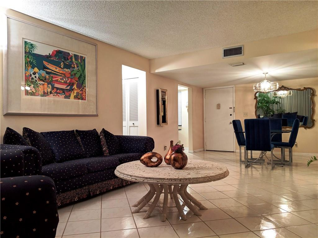 7650 West McNab Road, Unit 310 Tamarac, FL 33321 - Photo 5 of 30 a living room with furniture and a dining table with garden view