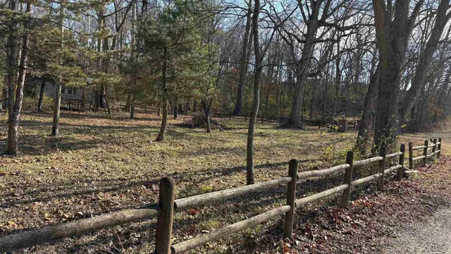 a view of a yard with wooden fence
