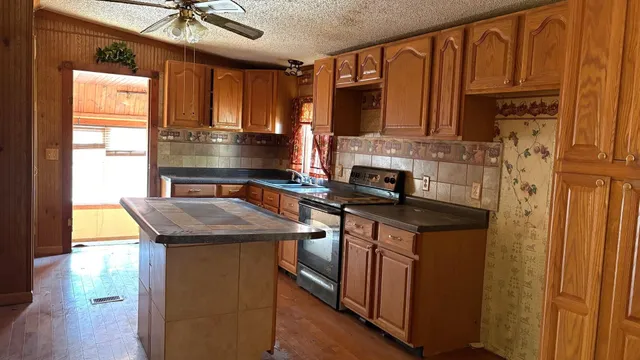 a kitchen with stainless steel appliances granite countertop a sink stove and cabinets