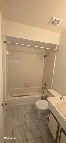 a bathroom with a granite countertop sink a toilet a mirror and shower