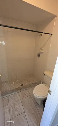 a bathroom with a toilet and a shower