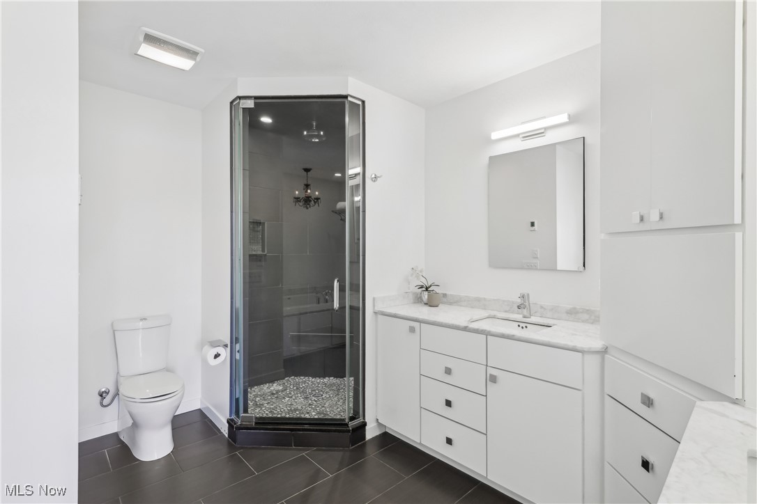 1852 Coltman Road Cleveland, OH 44106 - Photo 23 of 39 Primary Bathroom featuring a shower stall, tile patterned floors, toilet, vanity, and baseboards