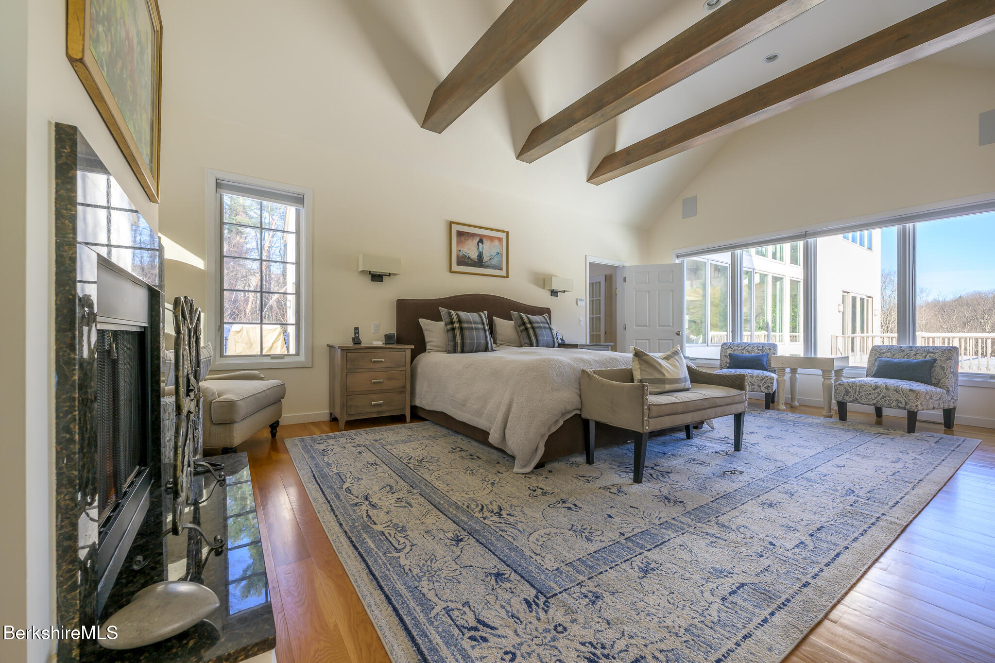 83 Maple Hill Road West Stockbridge, MA 01266 - Photo 32 of 86 a spacious bedroom with a bed a couch and a large window with wooden floor