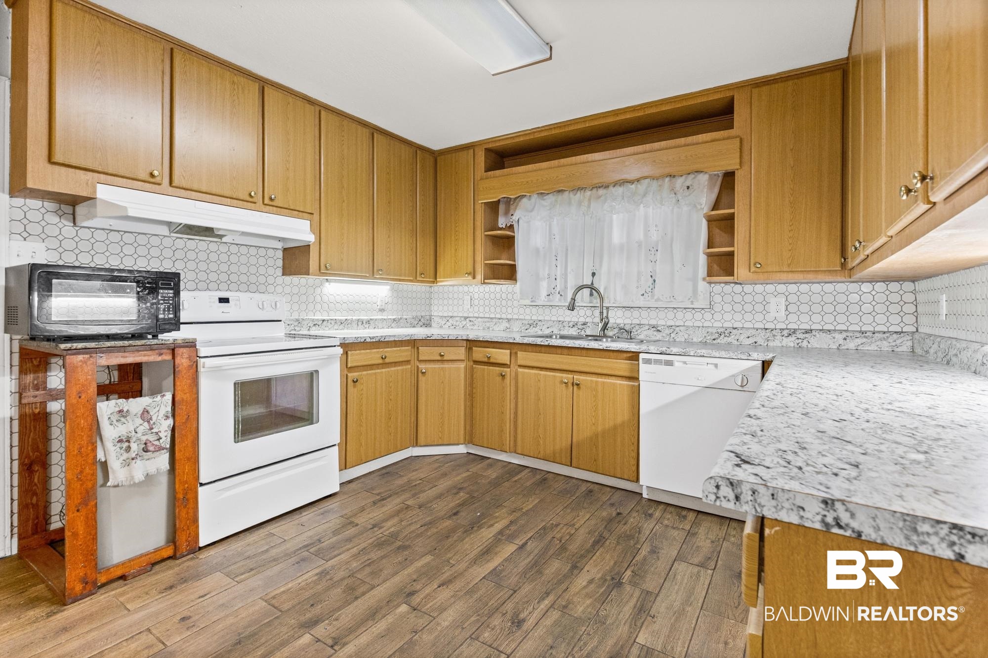 312 Sutherland Drive Mobile, AL 36611 - Photo 5 of 28 Kitchen featuring light wood-finish cabinetry, white appliances, and wood-finish flooring