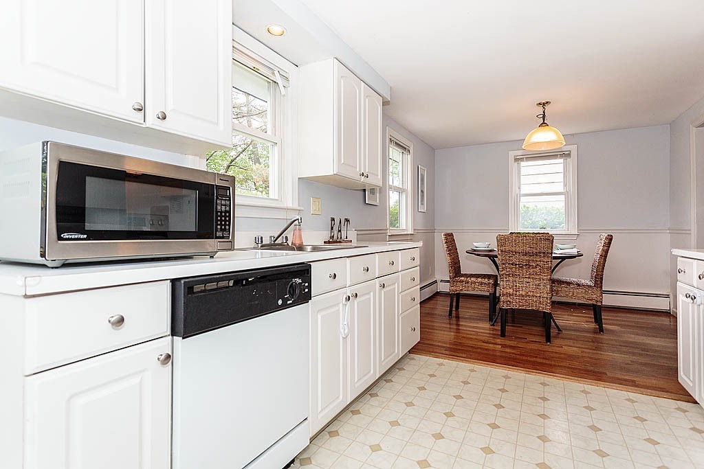 5 George Road, Unit 5 Winchester, MA 01890 - Photo 8 of 21 a kitchen with stainless steel appliances kitchen island granite countertop a stove a sink and a microwave