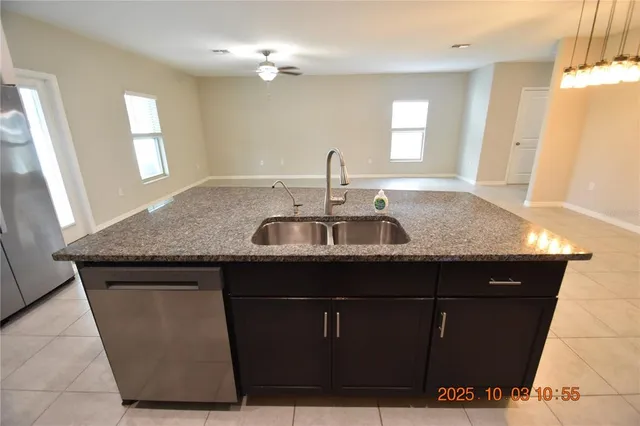 a kitchen with a sink a mirror and wooden cabinets