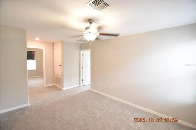 an empty room with a window and a chandelier fan