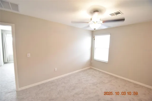 an empty room with a window and a fan
