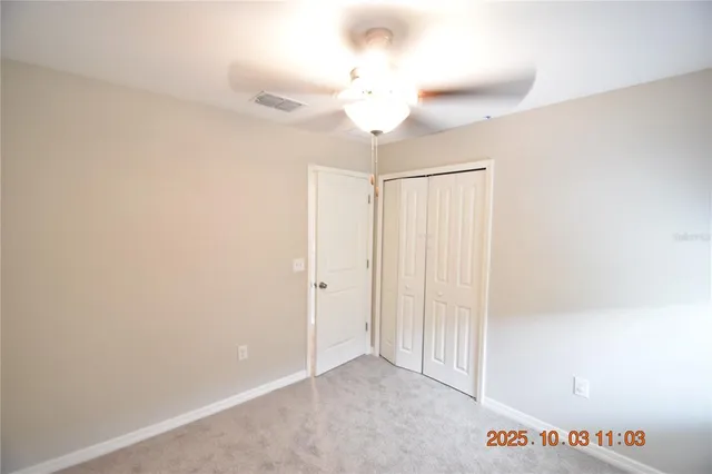 an empty room with a window and a fan