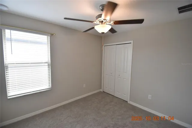 an empty room with a window and a fan