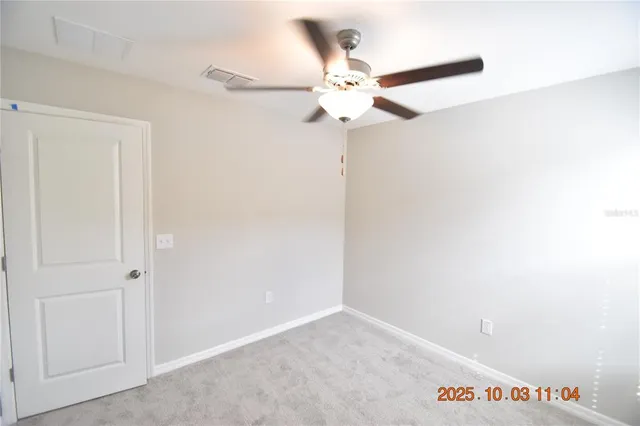 an empty room with a ceiling fan and a window