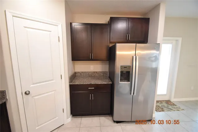 a metallic refrigerator freezer sitting in a kitchen