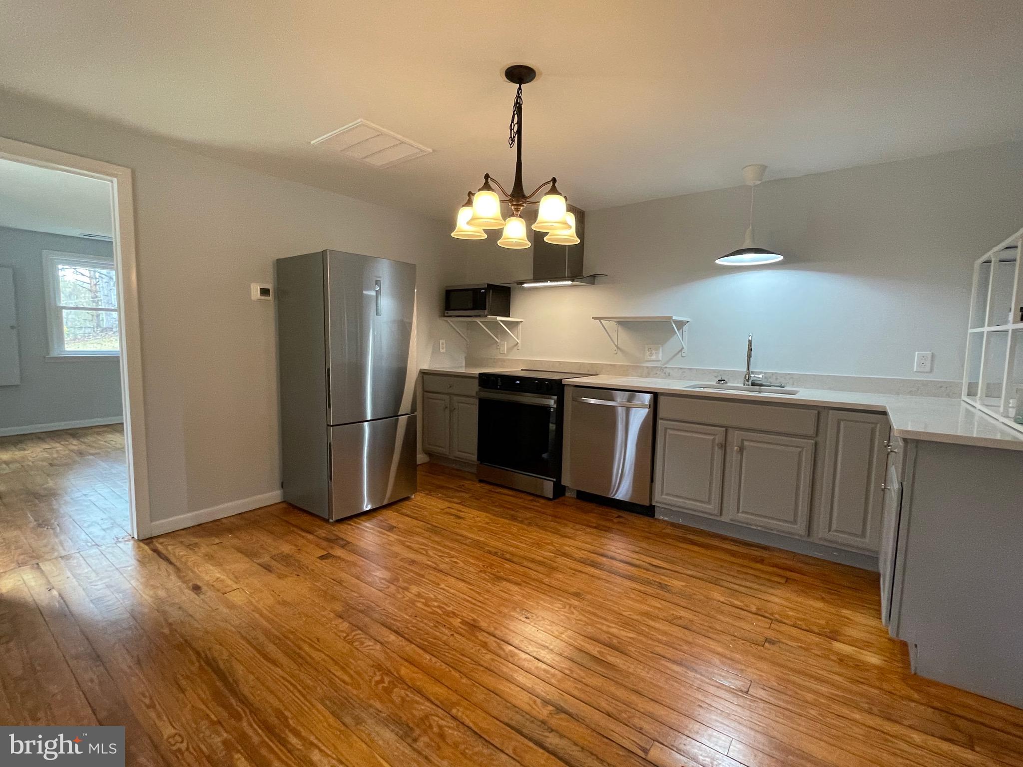 240 Whorton Hollow Road Castleton, VA 22716 - Photo 18 of 24 a view of a kitchen with wooden floor and stainless steel appliances