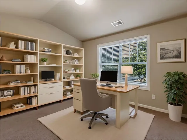a view of a workspace with furniture and a window