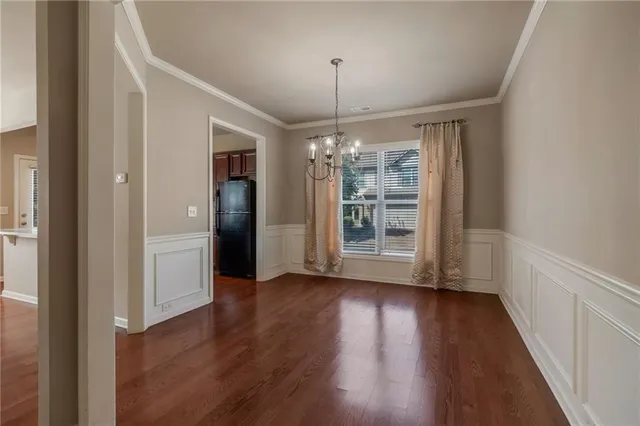 a view of a room with wooden floor chandelier and window