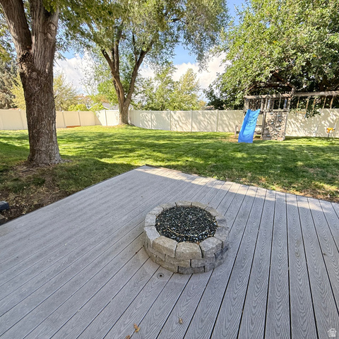 10240 Locksley Road Sandy, UT 84092 - Photo 25 of 27 Expansive backyard with a composite deck, built-in stone fire pit, and mature trees