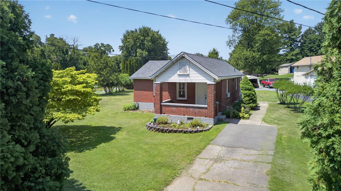 1166 Stones Crossing Road Easton, PA 18045 - Photo 23 of 35 A charming brick residence awaits, nestled amidst a verdant landscape with a convenient driveway.