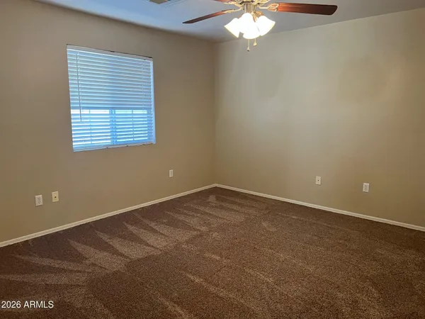 en empty room with windows and chandelier fan