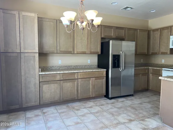 a kitchen with a refrigerator sink and cabinets