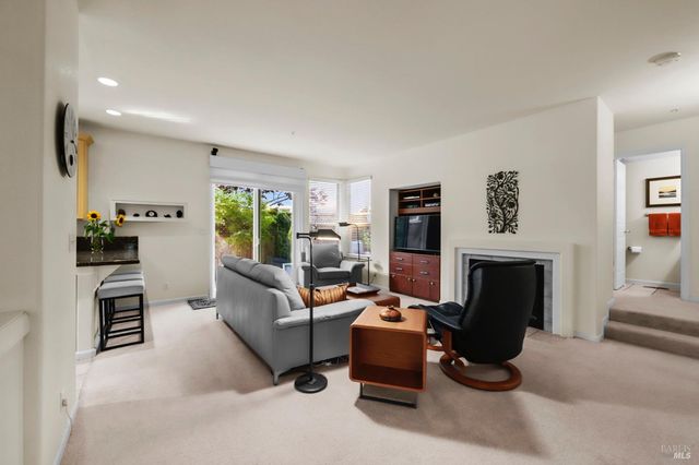 a living room with furniture a fireplace and a window