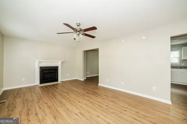 a view of an empty room with a window and a fireplace