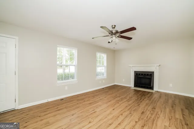 an empty room with windows and fireplace