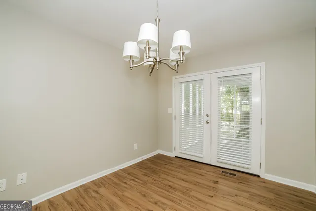 a view of a room with wooden floor and ceiling fan