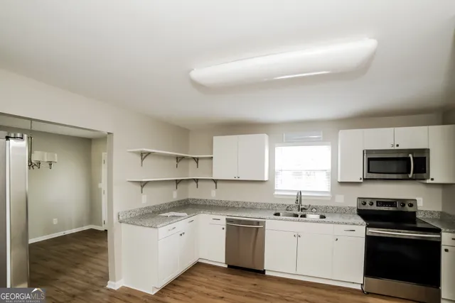 a kitchen with granite countertop a stove top oven sink and cabinets