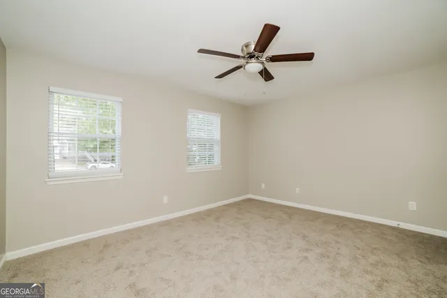 a view of a big room with wooden floor and windows