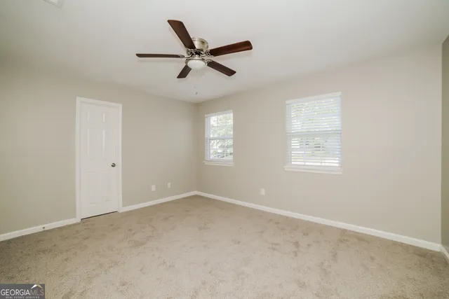 a view of a big room with wooden floor and windows