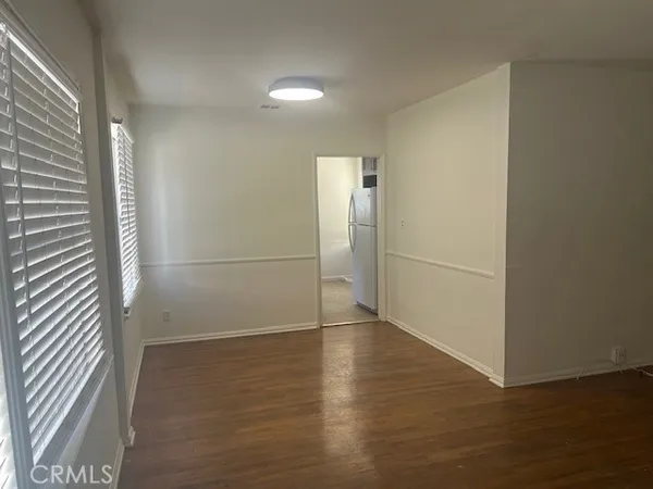 an empty room with wooden floor and a window