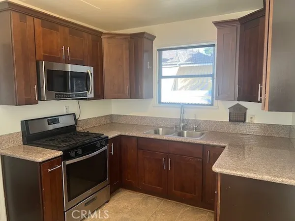 a kitchen with stainless steel appliances granite countertop a sink stove and microwave