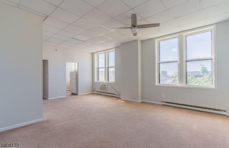 110 Cornelia Street, Unit 3 Boonton, NJ 07005 - Photo 4 of 15 an empty room with windows and chandelier fan
