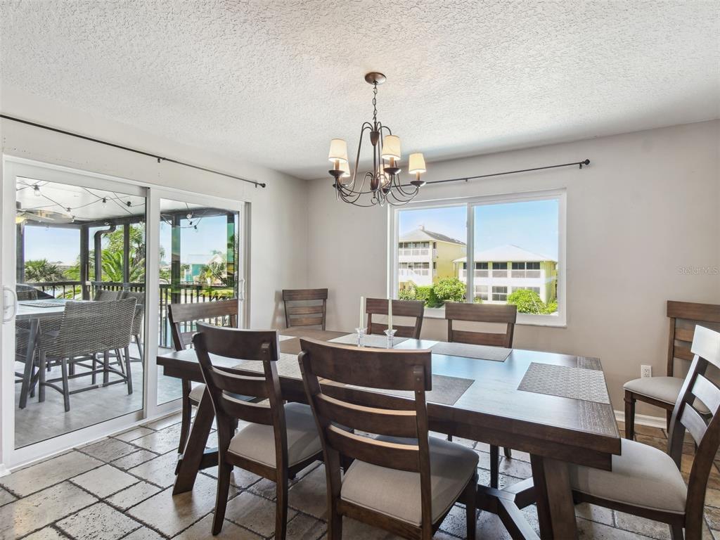 6241 Bayside Drive New Port Richey, FL 34652 - Photo 13 of 78 a dining room with wooden floor a chandelier a wooden table and chairs